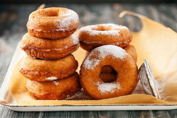 Homemade donuts  with powdered sugar on a wooden baclground