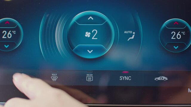 Close up finger of driver touching on digital monitor controller system on car for cool and fresh air.adjust air conditioner level in modern confort car.Car Technology Concept