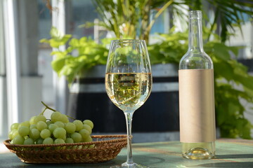 A glass of white wine with grapes on wooden table. White wine Riesling, from white grapes