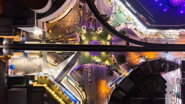 Time lapse of aerial view of Siam Bangkok Art and Skywalk aerial view in MBK Culture Center intersection or junction with cars traffic skyscraper buildings. Bangkok City in downtown at night, Thailand