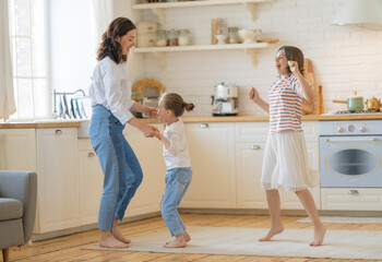 Mom and her daughters are dancing.