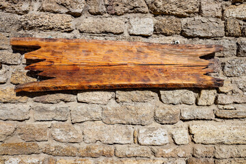 Empty wooden board for You text hangs on aged brick  wall. Image with copy-space