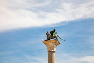 Bronze lion on the Piazza San Marco on blue sky background, Venice, Italy. Winged lion is a symbol...