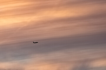 biplane flying high up in the sky against a sunset