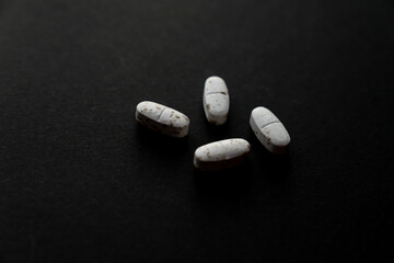 White spoiled pills covered with mold. Pills on a black background. The expiration date has expired