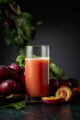 Plum juice and fresh purple plums.