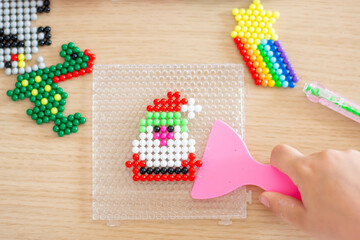 Handmade by children's hands, handmade aquamarine mosaic on the table during assembly, selective focus.
