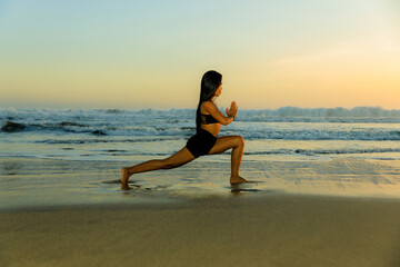 Beach yoga. Ashta chandrasana. High lunge pose lengthens the sides of the body, opens hips. Hands in namaste mudra. Healthy lifestyle. Yoga retreat. Fit body. Seminyak beach, Bali