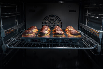Baking process of chocolate muffins in oven, home made. Sweet cupcakes with cocoa baked in oven.