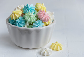 Small colorful meringues in the  ceramic bowl