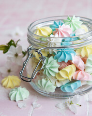 Small colorful meringues in the glass jar