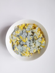 steam sticky rice with corn slices and mung bean above and Butterfly Pea flowers decoration.