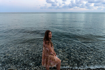 .young girl in the evening by the sea, sunset by the sea