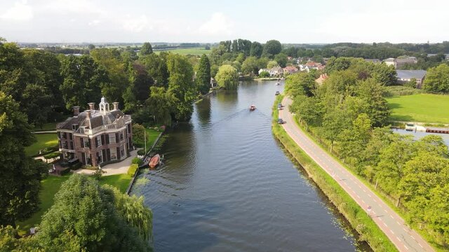 Aerial drone view of the river Nes Stichtse Vecht between Amsterdam and Utrecht with historic houses villa, along the water.