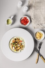 Pasta with seafood. Traditional Italian spaghetti with shrimps, mussels and squid with a spicy sauce. Mediterranean Kitchen. Top view. Vertical shot