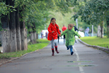 children run in raincoats / summer park, rain, walk brother and sister, children boy and girl