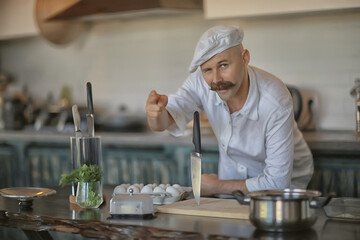 french chef in the kitchen preparing food, cooking, haute cuisine, man with mustache