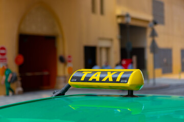 Taxi sign on the roof of a car in a street