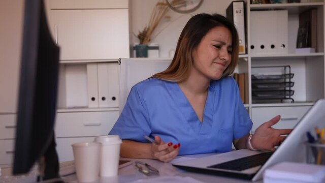 Woman doctor in uniform is working behind laptop in clinic. High quality FullHD footage