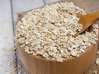oatmeal in a wooden bowl and spoon on a wooden table close-up