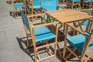 Fototapeta na wymiar Downtown restaurant terrace with folding canvas chairs