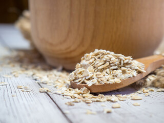 oatmeal in a wooden bowl and spoon on a wooden table close-up