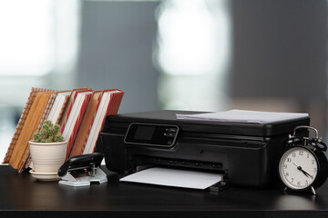 Stack of books and home printer against blurred background
