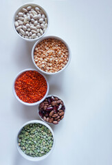 
Various legumes in plates lentils, peas, beans.