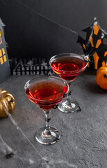 Two red Halloween cocktails with party decorations on dark background. Happy Halloween concept.