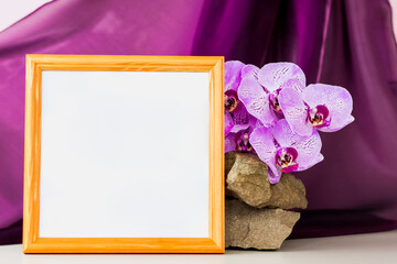 Obraz na płótnie Canvas Mockup. Photo frame on the background of beautiful orchids. Stylish appearance of the product, layout, personality