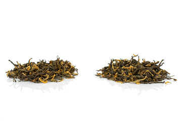 Dry black tea leaves in two groups in row isolated on white background