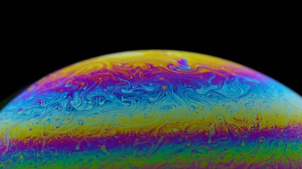 Half circle a soap bubble surface multicolored in motion isolated on black background. Vivid rainbow colors in weird and strange patterns. Close up. Slow motion.