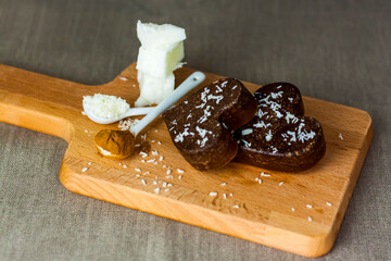 on the table there are handmade chocolates made of coconut oil, coconut chips and cocoa. dessert according to the recipe of proper nutrition.