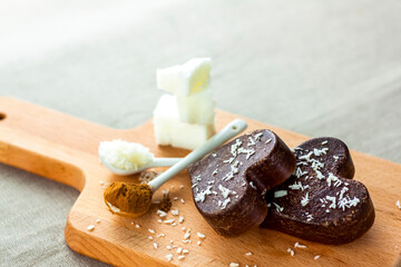 on the table there are handmade chocolates made of coconut oil, coconut chips and cocoa. dessert according to the recipe of proper nutrition.