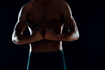 Fototapeta premium man with muscular abs cropped view of gym dark background