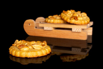 Group of three whole delicious cookie with peanuts with wooden sledge on black glass