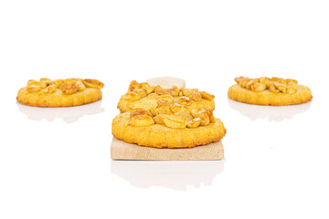 Group of four whole delicious cookie with peanuts on small wooden cutting board on white background