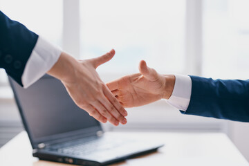Obraz premium colleagues shaking hands successful deal office laptop professionals