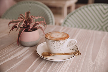 white cup of hot cappuccino on wooden light table background.