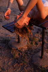Lying white european woman with sand on background sunset light
