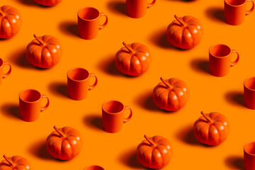 Fall season pattern of orange cups and small orange pumpkins on matching orange background....