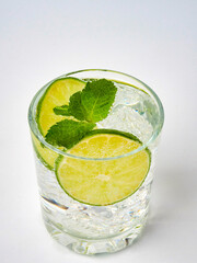 a glass of fresh drinking water and a lime. mineral water as a thirst quencher.