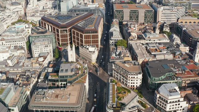 Aerial view of building in urban district. Tilt down footage of road intersection. Low traffic in streets around London Mithraeum. London, UK