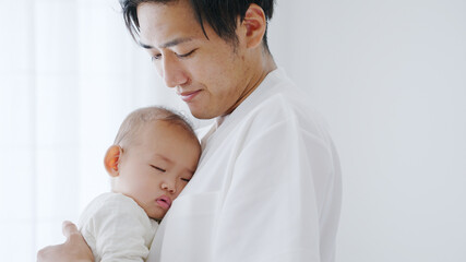 赤ちゃんを抱っこするイクメンなパパ（家族・ファミリー・育児・子育て）