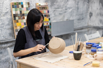 the master sculpts a clay pot in his workshop