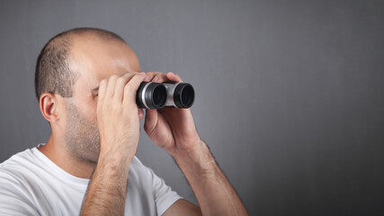 Man with binoculars looking into the distance.