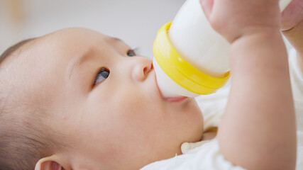 自分で哺乳瓶のミルクを飲む赤ちゃん（育児・子育て）