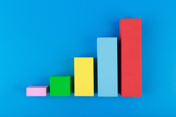 Business concept. Multicolored graph diagram with rise against blue background. Chart marketing,...