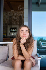 Young white european woman sitting on the sofa