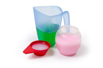 Various liquid laundry detergents in different measuring cups